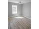 This bedroom has hardwood floors, a ceiling fan, and a window for natural light at 6881 Homestead Rd, Rex, GA 30273