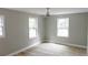 Bright bedroom featuring hardwood floors, two windows, and a ceiling fan at 6881 Homestead Rd, Rex, GA 30273