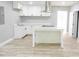 Bright, open kitchen featuring white cabinets, stainless steel appliances, and a center island at 6881 Homestead Rd, Rex, GA 30273