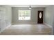 Spacious living room featuring hardwood floors, a window, and a dark wood door at 6881 Homestead Rd, Rex, GA 30273