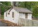 Side view of outdoor shed surrounded by leafy trees and weeds with a concrete wall at 6881 Homestead Rd, Rex, GA 30273