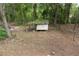 Ground-level view of a small shed in a wooded lot with a dirt path at 6881 Homestead Rd, Rex, GA 30273