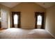 Bright living room featuring carpet and large windows adorned with decorative curtains at 115 Catlyn Ct, Riverdale, GA 30296