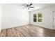Bright bedroom with wood-look floors, ceiling fan, and natural light from the window at 197 Holcomb Ferry Rd, Roswell, GA 30076