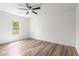 Bright bedroom with wood-look floors, ceiling fan, and natural light from the window at 197 Holcomb Ferry Rd, Roswell, GA 30076