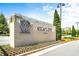 Community entrance sign with a modern design, surrounded by lush landscaping and mature trees at 197 Holcomb Ferry Rd, Roswell, GA 30076