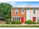 Charming brick townhome featuring a bright red front door and meticulously maintained landscaping at 197 Holcomb Ferry Rd, Roswell, GA 30076