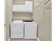 Convenient laundry area offers a washer, dryer, overhead cabinets and shelving at 3401 Ravensworth Trce, Kennesaw, GA 30144