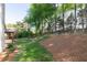 Serene backyard featuring a lush green lawn, mature trees, and a charming deck area at 5405 Preserve Cir, Johns Creek, GA 30005