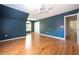 Spacious bedroom features hardwood floors, a ceiling fan, and a large window, providing ample natural light at 5405 Preserve Cir, Johns Creek, GA 30005