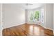 Empty room featuring gleaming hardwood floors and natural light from the bay window at 5405 Preserve Cir, Johns Creek, GA 30005