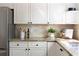 Detailed view of kitchen countertop featuring granite, stainless steel appliances, white cabinets and stylish backsplash at 5405 Preserve Cir, Johns Creek, GA 30005