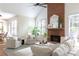 Spacious living room featuring a brick fireplace, large windows, and comfortable seating at 5405 Preserve Cir, Johns Creek, GA 30005