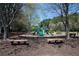 Community playground featuring slides, swings, and benches surrounded by trees at 5405 Preserve Cir, Johns Creek, GA 30005