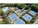 Aerial view of multiple tennis courts and community building surrounded by lush greenery at 5405 Preserve Cir, Johns Creek, GA 30005