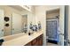 Bright bathroom with a sink and cabinets, and a doorway leading to shower at 542 Simonton Ridge Trl, Lawrenceville, GA 30045