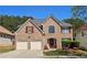 Charming brick two-story home with a well-manicured lawn and a two-car garage at 542 Simonton Ridge Trl, Lawrenceville, GA 30045