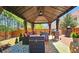 Well-appointed gazebo with seating, grill, and colorful rug for outdoor enjoyment and entertainment at 542 Simonton Ridge Trl, Lawrenceville, GA 30045