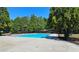 A pristine, in-ground swimming pool surrounded by a well-maintained concrete patio and mature trees at 542 Simonton Ridge Trl, Lawrenceville, GA 30045