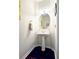 Small powder room with a pedestal sink, oval mirror, and dark wood floors at 542 Simonton Ridge Trl, Lawrenceville, GA 30045