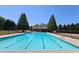 A pristine swimming pool with lane markers, surrounded by lush greenery and a secure fence at 542 Simonton Ridge Trl, Lawrenceville, GA 30045