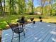 Back deck with outdoor seating and colorful potted plants in a large backyard with mature trees at 1835 Penrose Ct, Powder Springs, GA 30127