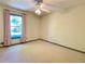 Bright bedroom featuring a ceiling fan and a large window with neutral carpet at 1835 Penrose Ct, Powder Springs, GA 30127