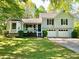 Charming home featuring a well-manicured lawn, inviting front porch, and attached two-car garage at 1835 Penrose Ct, Powder Springs, GA 30127