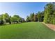Expansive backyard with lush green lawn and mature trees, ideal for outdoor activities at 2199 Tayside Nw Xing, Kennesaw, GA 30152