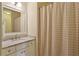 Well-lit bathroom with neutral color scheme, vanity, shower curtain, and mirror offering relaxation at 2199 Tayside Nw Xing, Kennesaw, GA 30152