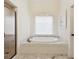 Bright bathroom with a marble countertop, soaking tub, and seamless glass shower at 2199 Tayside Nw Xing, Kennesaw, GA 30152