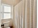 Bathroom features a toilet, neutral-toned shower curtain, and window that gives a simple and functional space at 2199 Tayside Nw Xing, Kennesaw, GA 30152
