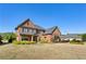 A stately brick home with well-maintained landscaping and large windows under a clear, bright sky at 2199 Tayside Nw Xing, Kennesaw, GA 30152