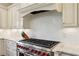 Close-up of a professional-grade stainless steel stove with red knobs and custom white cabinetry at 2199 Tayside Nw Xing, Kennesaw, GA 30152