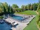 Backyard pool area featuring a fenced-in pool, lounging chairs, and ample green space for outdoor enjoyment at 2199 Tayside Nw Xing, Kennesaw, GA 30152