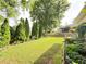 Spacious backyard with manicured lawn, mature trees, garden, and wood privacy fence at 4025 Mcdowell Dr, Acworth, GA 30101