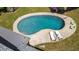 An aerial view of a kidney-shaped swimming pool surrounded by trees and lounge chairs at 4841 Village North Ct, Atlanta, GA 30338