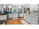 Renovated kitchen featuring white cabinets, stainless steel appliances, and blue backsplash at 4841 Village North Ct, Atlanta, GA 30338