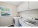 Bright laundry room with washer, dryer, sink, and plenty of cabinet space at 4841 Village North Ct, Atlanta, GA 30338