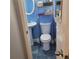 A compact blue bathroom features a pedestal sink, toilet, and shelving for storage at 2007 Mesa Se Dr, Atlanta, GA 30316