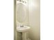 Elegant half-bathroom with a pedestal sink, oval mirror, and stylish lighting, maximizing a small space at 2225 Bigwood Trl, Atlanta, GA 30349