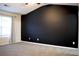 Spacious carpeted bedroom features a dark accent wall and window with neutral colored curtain at 2225 Bigwood Trl, Atlanta, GA 30349