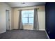 Well-lit bedroom with neutral colored walls, carpet flooring, and window with blinds and gray curtain at 2225 Bigwood Trl, Atlanta, GA 30349
