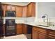 Modern kitchen with dark wood cabinets, stainless steel appliances, light countertops and luxury vinyl plank flooring at 2225 Bigwood Trl, Atlanta, GA 30349