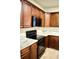 Kitchen with dark wood cabinets, black appliances, light countertops, and luxury vinyl plank flooring at 2225 Bigwood Trl, Atlanta, GA 30349