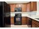 Modern kitchen with dark wood cabinets, stainless steel appliances, light countertops and luxury vinyl plank flooring at 2225 Bigwood Trl, Atlanta, GA 30349