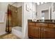 A well-lit bathroom with a shower-tub combo and vanity offering functional style and comfort at 225 Mystic Ridge Hl, Sandy Springs, GA 30342