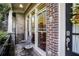 Inviting front porch with brick detail, an outdoor seating area and view of the home's entryway at 225 Mystic Ridge Hl, Sandy Springs, GA 30342