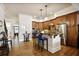 Spacious kitchen with an island, wooden cabinetry, hardwood floors and a seamless transition to other rooms at 225 Mystic Ridge Hl, Sandy Springs, GA 30342