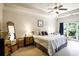 Bright main bedroom featuring a tray ceiling, ceiling fan, large windows, and stylish decor and furnishings at 225 Mystic Ridge Hl, Sandy Springs, GA 30342